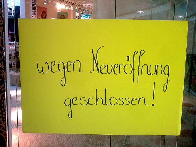 Plakat am Fenster eines Geschäftes: "wegen Neueröffnung geschlossen!"